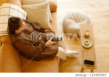 ソファーに座ってテレビを見てくつろいでいる女性 ソファーに座ってテレビを見てくつろいでいる女性 115493093