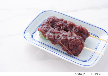 蓬を使った草餅で作った緑色のおだんごに、こしあんをたっぷり載せた、よもぎ団子 115493106