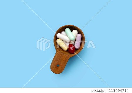 Colorful capsules and pills on blue background. Colorful capsules and pills on blue background. 115494714