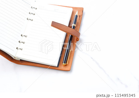 リング式のシステム手帳を開いてデスクワークをしているイメージ リング式のシステム手帳を開いてデスクワークをしているイメージ 115495345