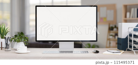 A computer with a white-screen mockup and office supplies on a desk in a modern private office. A computer with a white-screen mockup and office supplies on a desk in a modern private office. 115495371