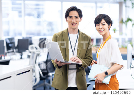 オフィスで打ち合わせをする若い男女のエンジニア オフィスで打ち合わせをする若い男女のエンジニア 115495696