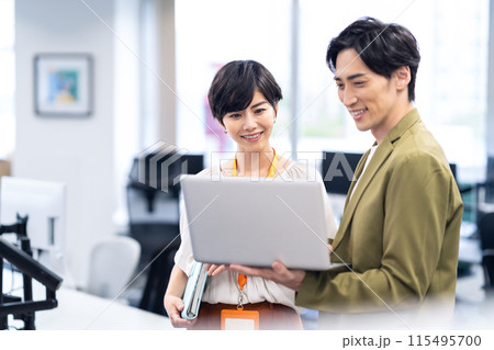 オフィスで打ち合わせをする若い男女のエンジニア オフィスで打ち合わせをする若い男女のエンジニア 115495700