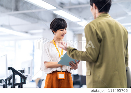 オフィスで打ち合わせをする若い男女のエンジニア 115495706
