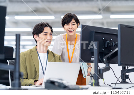 オフィスで打ち合わせをする若い男女のエンジニア 115495715