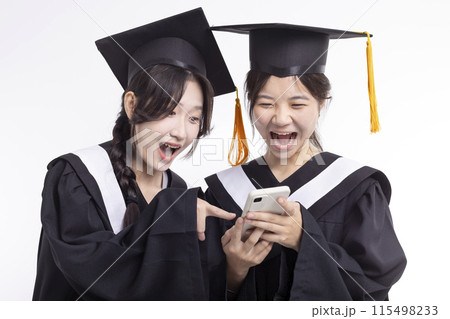 Happy  girl friend graduates  in cap and gown watching the smart phone 115498233