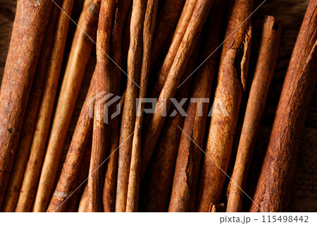 Cinnamon sticks dried tree bark spice on rustic wooden table background. Selective focus. 115498442