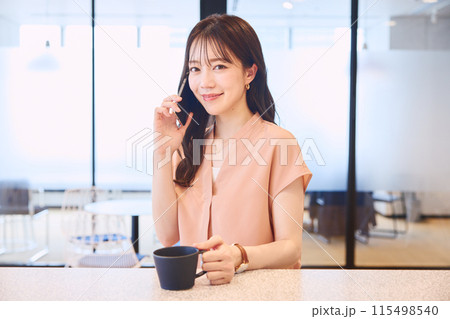 オフィスのパンドリーで電話をする女性 115498540