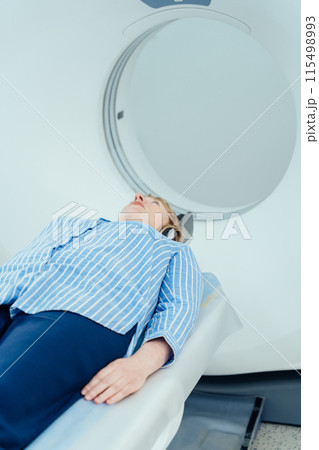 Blond mature woman enters into MRI capsule. Blond mature woman enters into MRI capsule. 115498993