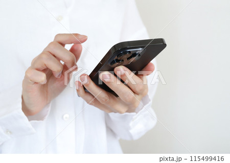 スマホを使う手元 115499416