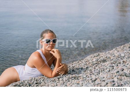 Freelance close up woman hands writing on computer. Well looking middle aged woman typing on laptop keyboard outdoors with beautiful sea view. 115500973