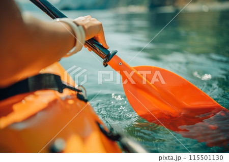 Kayak paddle sea vacation. Person paddles with orange paddle oar on kayak in sea. Leisure active lifestyle recreation activity rest tourism travel Kayak paddle sea vacation. Person paddles with orange paddle oar on kayak in sea. Leisure active lifestyle recreation activity rest tourism travel 115501130