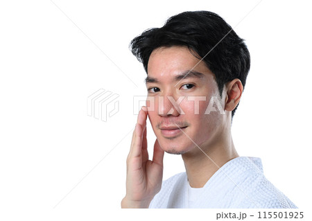 Handsome man wearing bathrobe touching his face isolate on white background. Skin care and beauty treatment concept 115501925