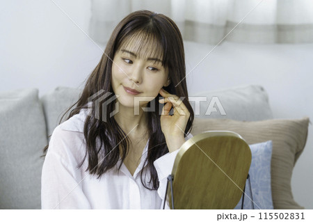 鏡を見てお肌の調子をチェックする若い女性 115502831