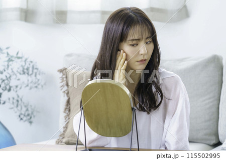 鏡を見てお肌の調子をチェックする若い女性 115502995