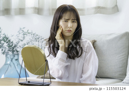 鏡を見て憂鬱になる若い女性 115503124