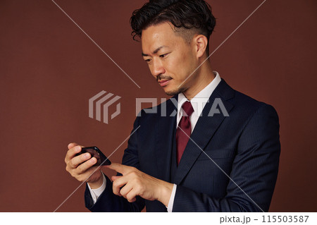 スマホで観戦するビジネスマン 115503587