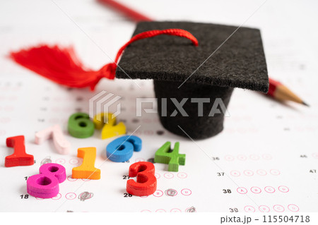 Graduation gap hat and pencil on answer sheet paper, Education study testing learning teach concept. Graduation gap hat and pencil on answer sheet paper, Education study testing learning teach concept. 115504718