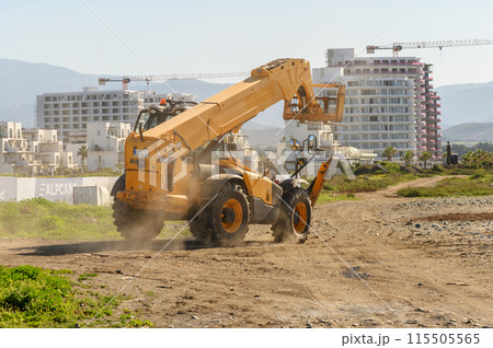 yellow front loader goes to a construction site 2 115505565