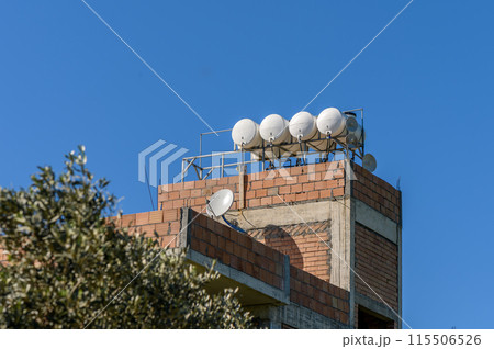 Gaziveren/ Cyprus-01.03.2024 Water tanks on the roof of a house in a village in Cyprus 1 115506526