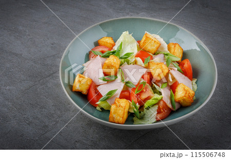 Close-up of salad with ham and halloumi cheese in a bowl on the table 1 115506748