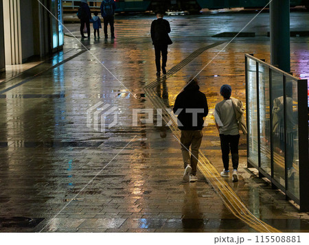 雨の日の夜の富山駅前広場で歩くサラリーマンと観光客の姿 雨の日の夜の富山駅前広場で歩くサラリーマンと観光客の姿 115508881