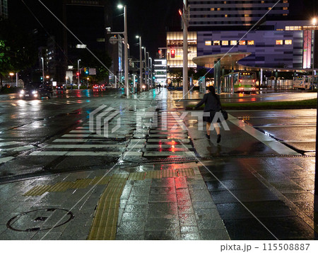 雨の日の夜の富山駅前広場で歩く女子高生の姿 115508887