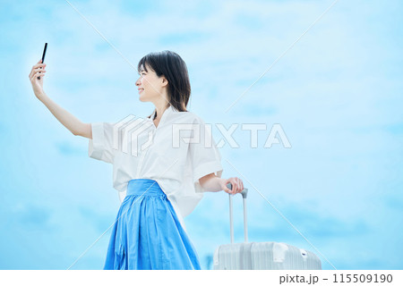 スーツケースを手に歩く若い女性 115509190