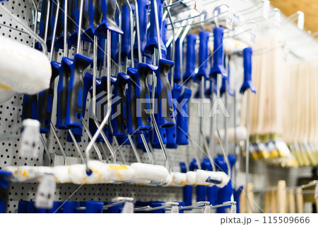 A store display of paint brushes and rollers. The display is organized by color and size. 115509666