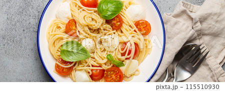Spaghetti with cherry tomatoes and mozzarella being served on a plate Spaghetti with cherry tomatoes and mozzarella being served on a plate 115510930