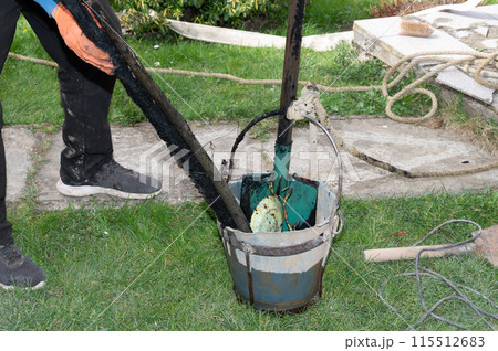 Near the well, after cleaning the bottom, there is a bucket with objects that were inside. 115512683