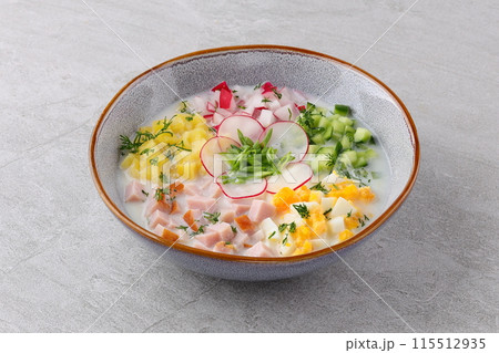 Traditional Russian summer cold soup okroshka with kefir in ceramic bowl on rustic wooden table 115512935