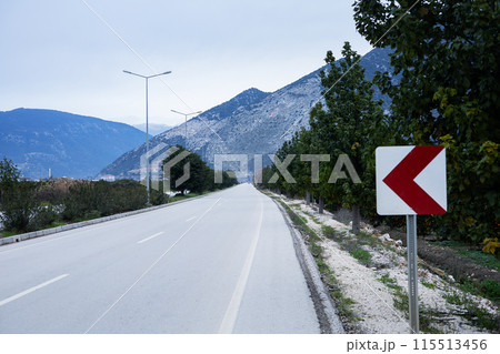 Scenic mountain road with directional sign Scenic mountain road with directional sign 115513456