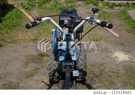 Walk-behind tractor on the grass in the yard, close-up Walk-behind tractor on the grass in the yard, close-up 115514085