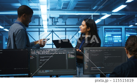 Technician and team leader in server farm looking for equipment misconfigurations affecting performance. Multiethnic coworkers checking data center infrastructure bottlenecks leading to glitches 115515819