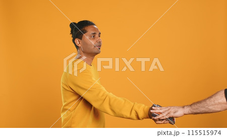 Friendly upbeat pizza delivery employee giving takeaway order to client paying with credit card. Asian man offering food order and digital payment method to customer, studio background, camera A Friendly upbeat pizza delivery employee giving takeaway order to client paying with credit card. Asian man offering food order and digital payment method to customer, studio background, camera A 115515974