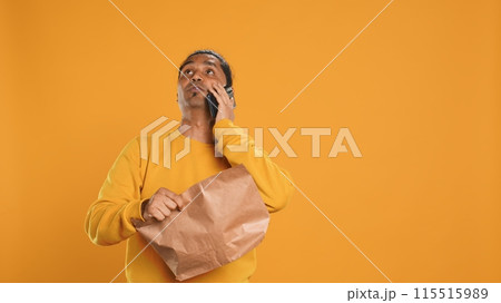 Delivery man arguing with customer on phone after arriving at destination and waiting for him, studio background. Indian person doing deliveries, scolding late client on telephone call, camera A Delivery man arguing with customer on phone after arriving at destination and waiting for him, studio background. Indian person doing deliveries, scolding late client on telephone call, camera A 115515989
