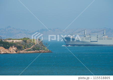 Maritime scene with rocky outcrop and ship sailing in San Francisco Bay area. Rolling hills and light haze in the background add to the atmospheric perspective. 115518805