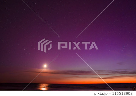 Stunning view of the aurora borealis with vibrant purple and orange hues, a bright moon reflecting on the calm Baltic Sea near Riga and Jurmala in Latvia. Stunning view of the aurora borealis with vibrant purple and orange hues, a bright moon reflecting on the calm Baltic Sea near Riga and Jurmala in Latvia. 115518908