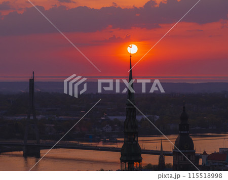 Magical aerial sunset over Riga old town, the capital of Latvia. Riga rooftop view panorama at sunset with urban architectures and Daugava River. Magical aerial sunset over Riga old town, the capital of Latvia. Riga rooftop view panorama at sunset with urban architectures and Daugava River. 115518998