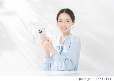 スマホを持ち微笑む女性 115519134