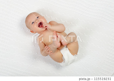 Little baby on white bed 115519231