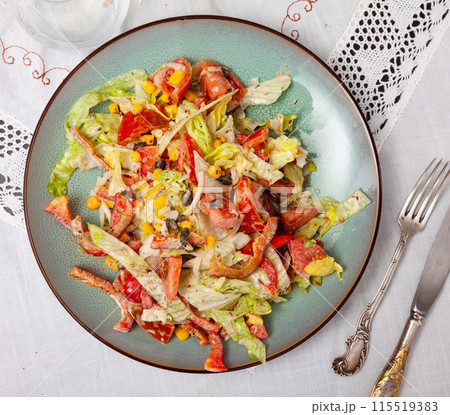 On plate, portion is laid out with pim salad of corn, cabbage, mayonnaise. 115519383