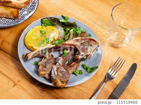 Lamb ribs served with potatoes and peppers 115519408