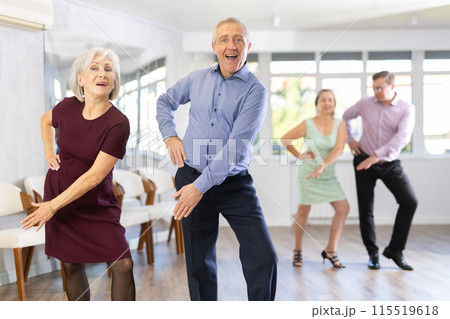 Happy senior woman and man enjoying active boogie-woogie dance in studio. Social dancing concept Happy senior woman and man enjoying active boogie-woogie dance in studio. Social dancing concept 115519618