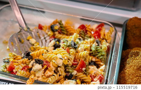 Pasta and pesto salad displayed in deli section of local store 115519716