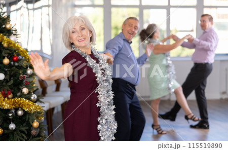 In studio decorated for New Year, elderly man and woman perky dance pair discofox. 115519890