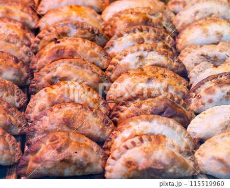 Appetizing savory empanadas showcased on countertop display Appetizing savory empanadas showcased on countertop display 115519960