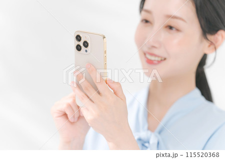 スマホを持ち微笑む女性 スマホを持ち微笑む女性 115520368