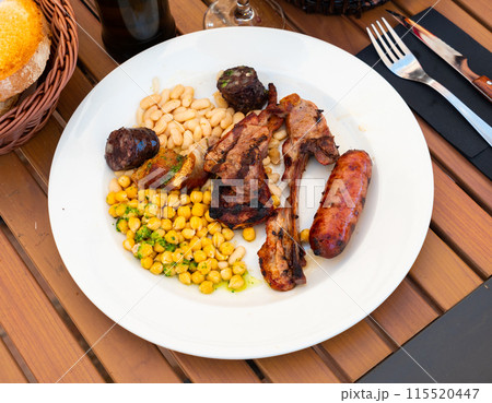 Grilled meat served with beans and chickpeas Grilled meat served with beans and chickpeas 115520447